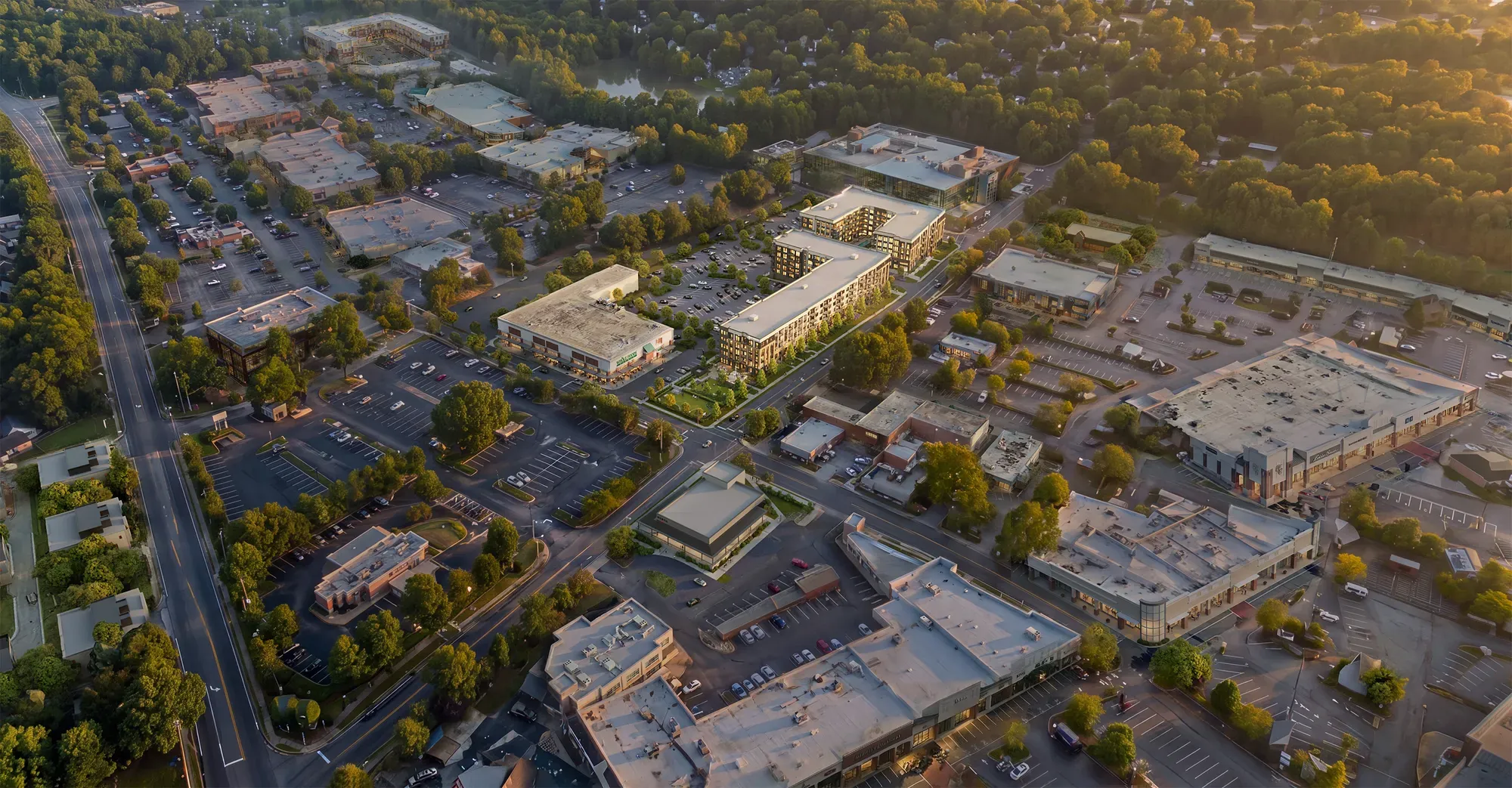 Aerial view of Pembroke at Friendly Center apartments surrounded by shops and trees in Greensboro, NC