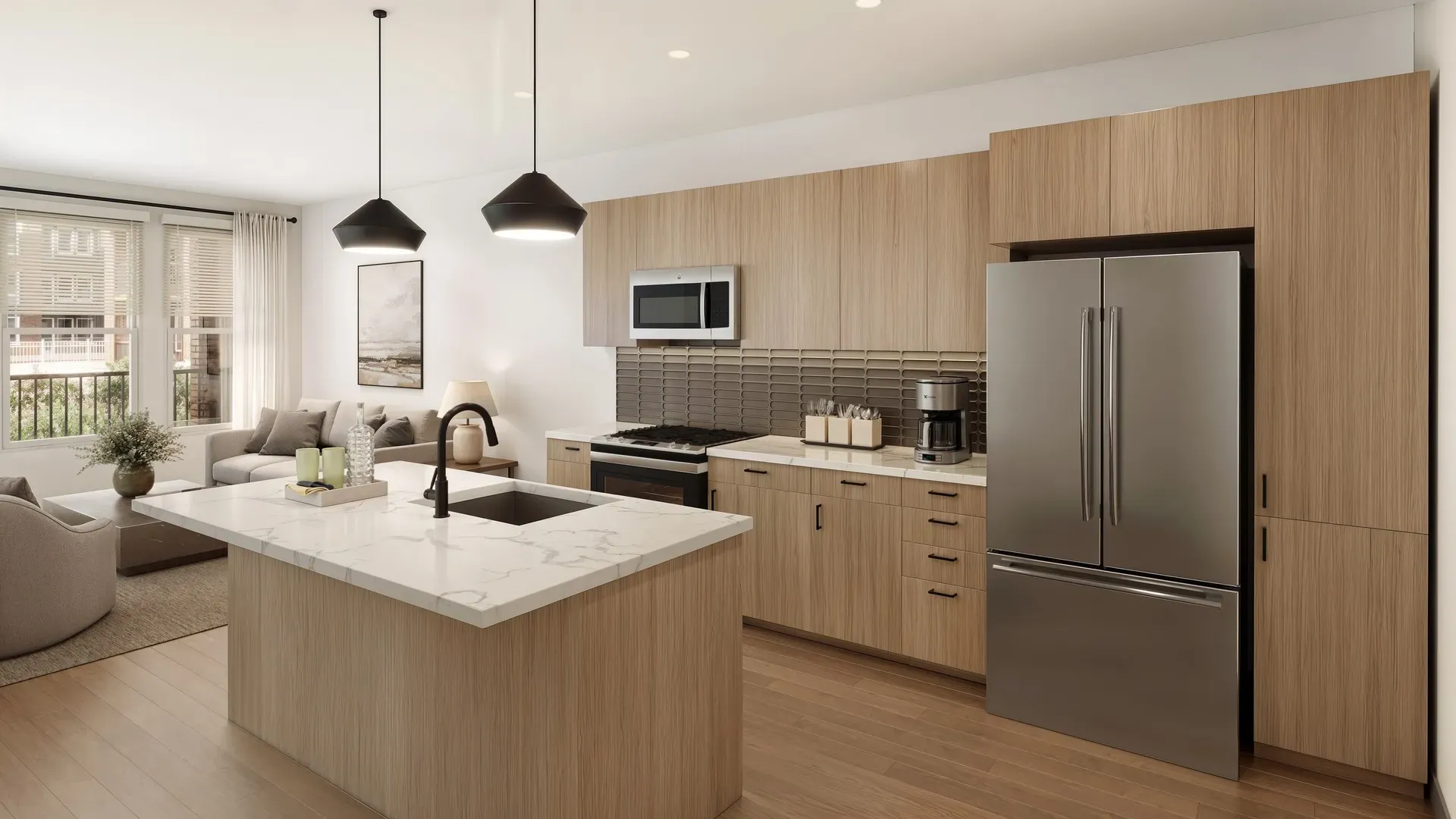 Open-concept apartment kitchen with quartz island and stainless appliances at Pembroke at Friendly Center, NC